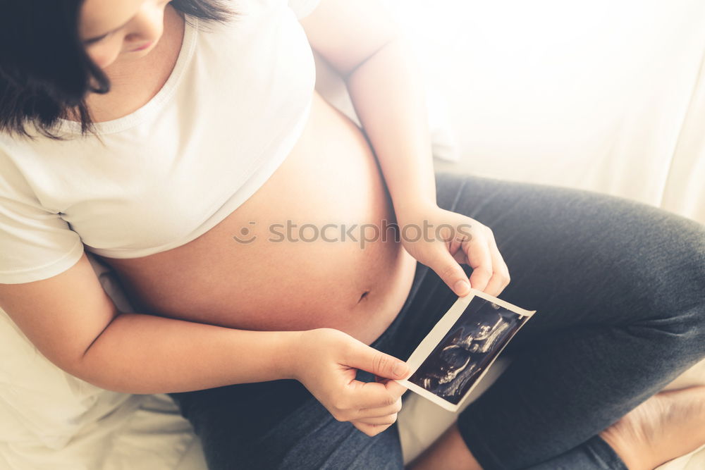 Similar – Image, Stock Photo pregnant woman sitting on the bench and loocking ultrasound scan at the day time. Concept of happy expectation.