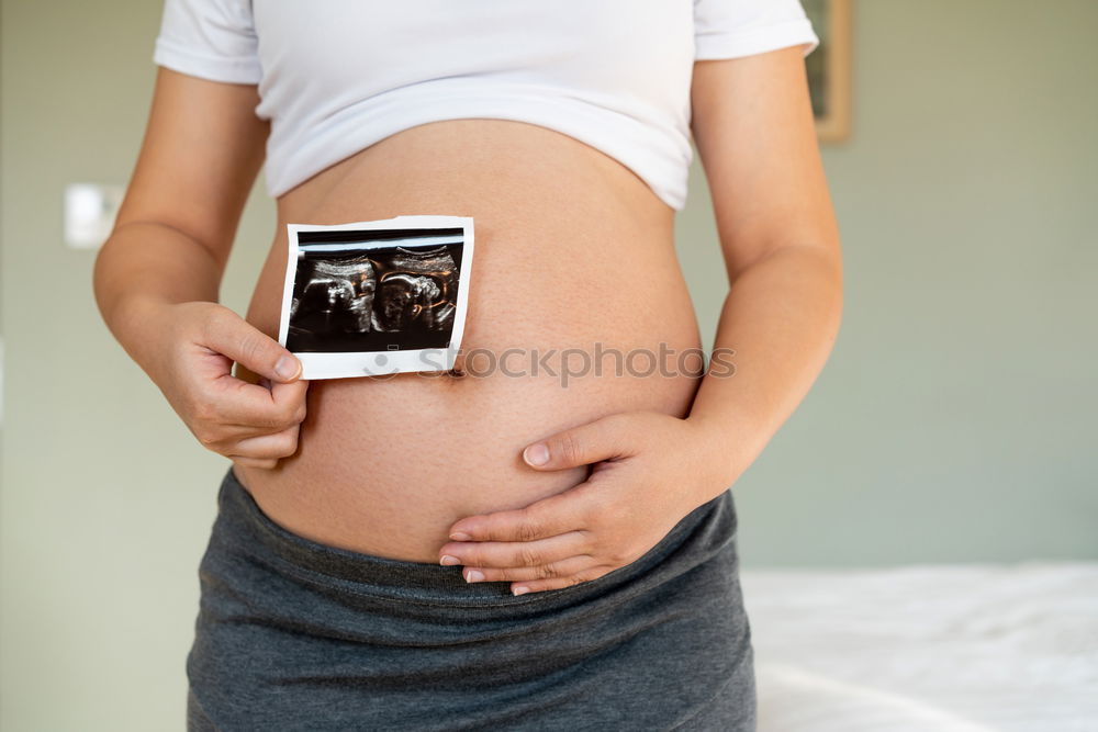 Similar – Schwangerschaftstests, Babykleidung und Ultraschalluntersuchung auf dem Bett, Ansicht von oben