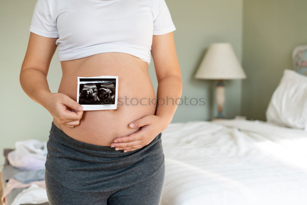 Similar – Schwangerschaftstests, Babykleidung und Ultraschalluntersuchung auf dem Bett, Ansicht von oben