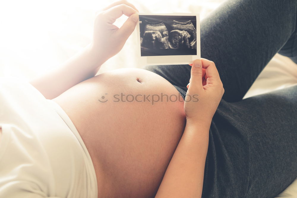 Similar – Image, Stock Photo pregnant woman sitting on the bench and loocking ultrasound scan at the day time. Concept of happy expectation.