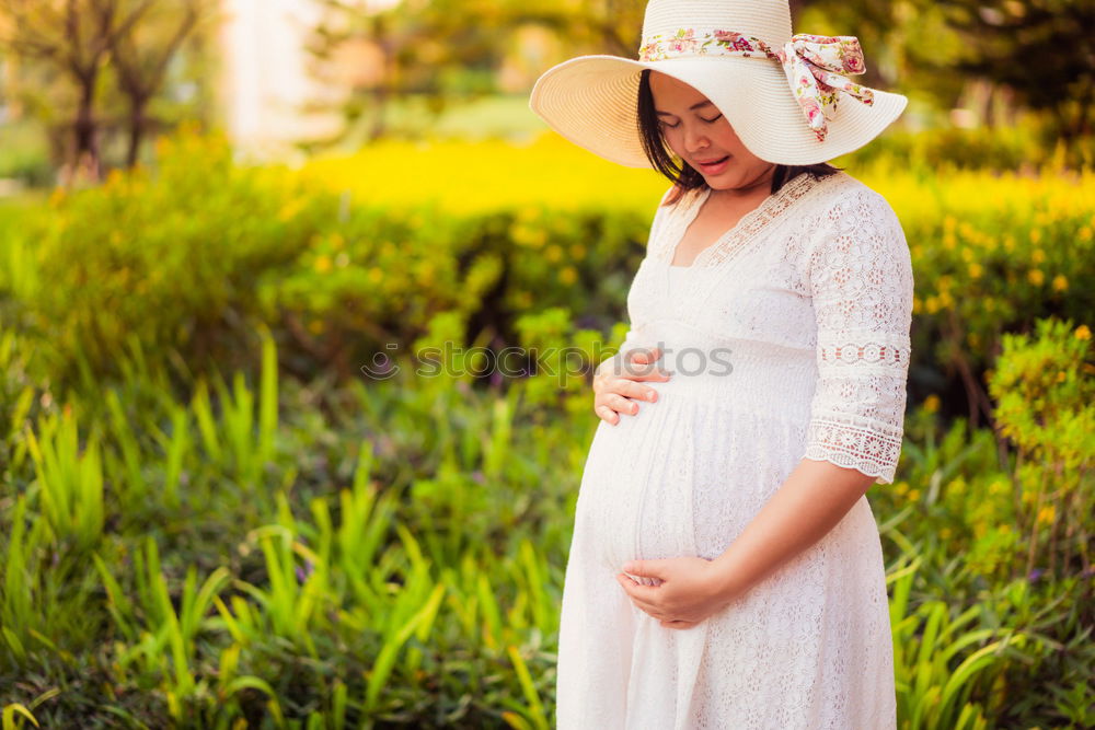 Similar – Image, Stock Photo Closeup shot of bare belly of pregnant woman. She’s holding a flower by it.