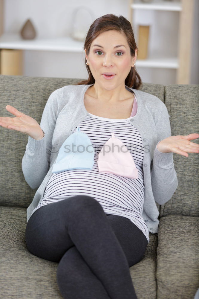 Similar – Young woman sits on the couch and sticks out one leg