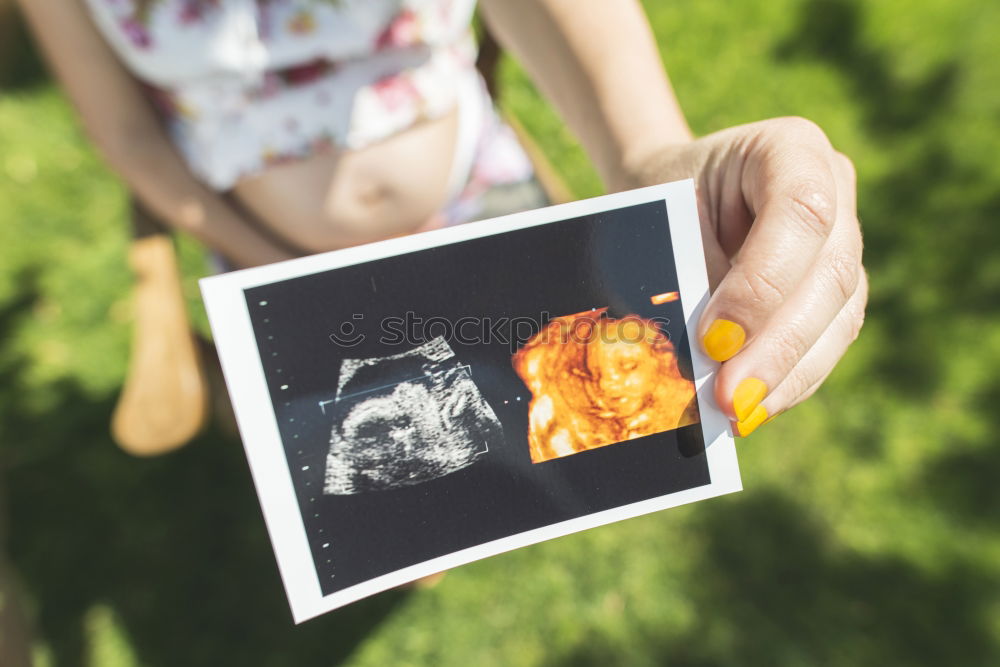 Image, Stock Photo pregnant woman sitting on the bench and loocking ultrasound scan at the day time. Concept of happy expectation.