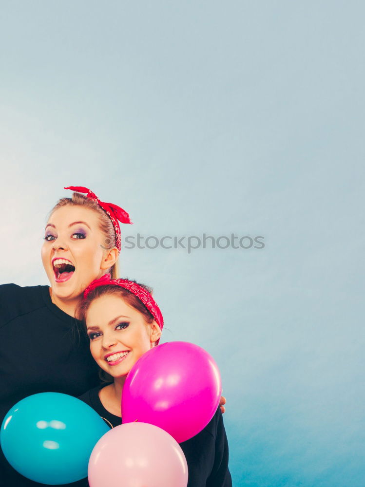 Young adult best friends cheering with confetti on party