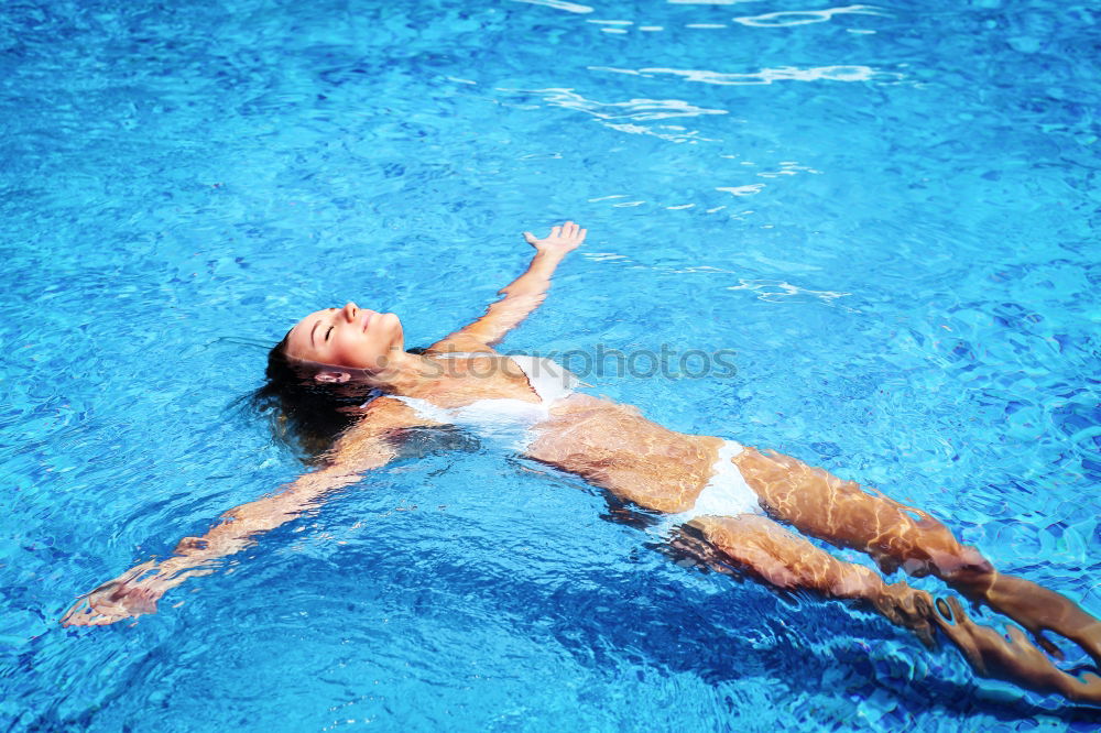 Similar – Woman swimming underwater in blue sea