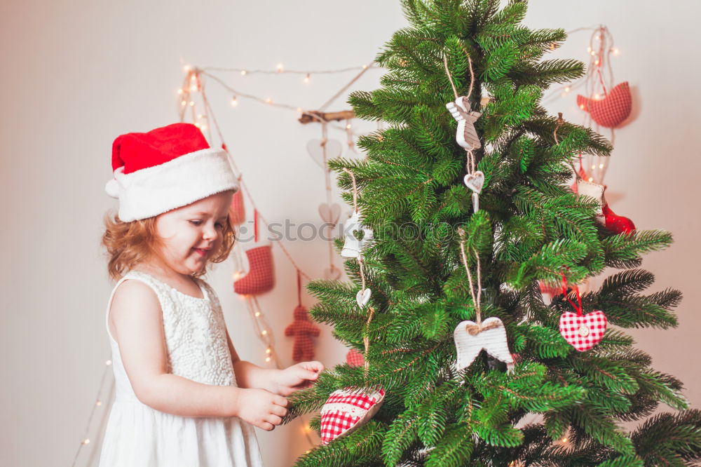 Similar – Young girl and her little sister decorating Christmas tree