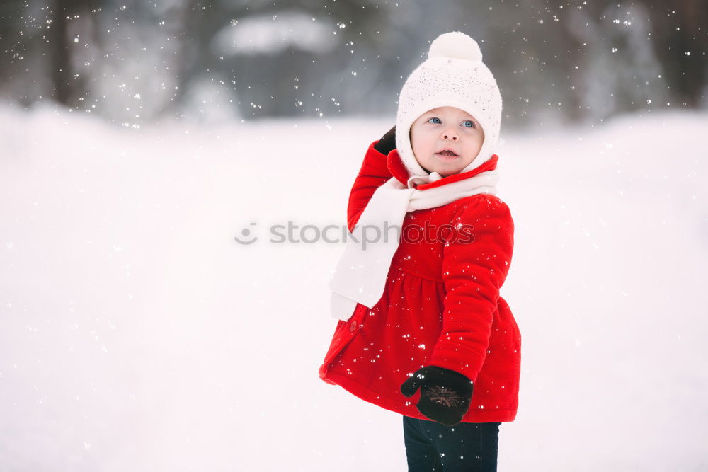 Similar – Little boy having fun playing with fresh snow during snowfall. Baby catching snowflakes on gloves. Kid dressed in warm clothes, hat, hand gloves and scarf. Active winter outdoors leisure for child