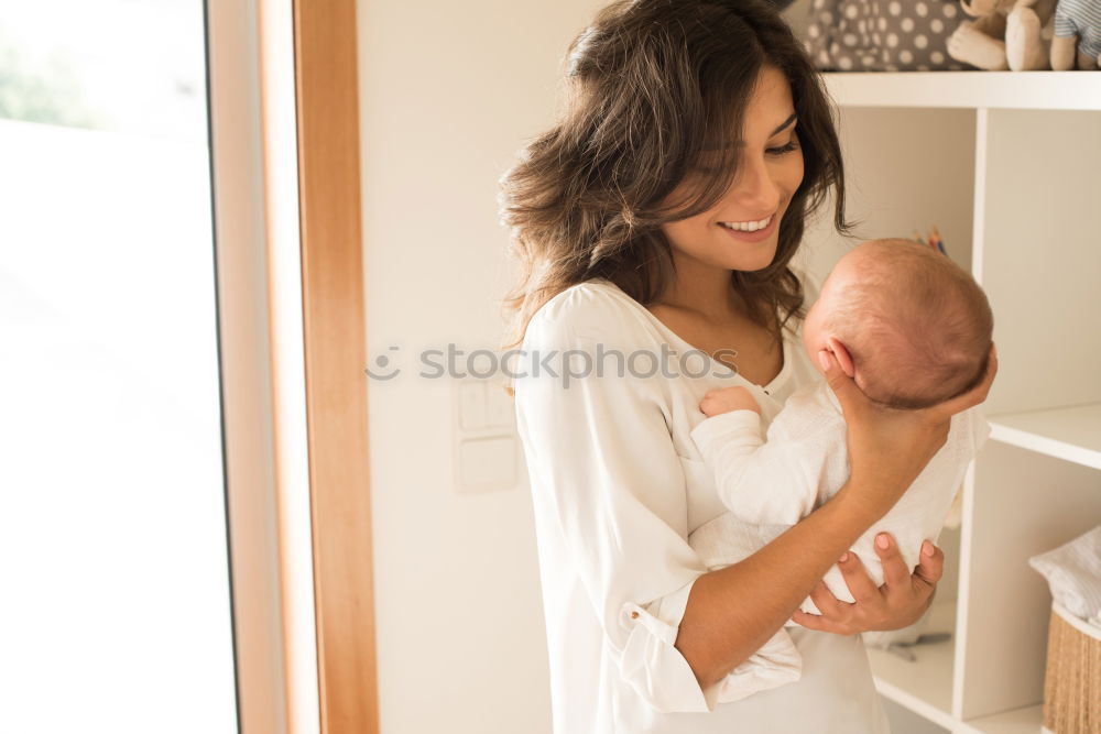 Similar – Image, Stock Photo Young mother holding her baby in the bedroom