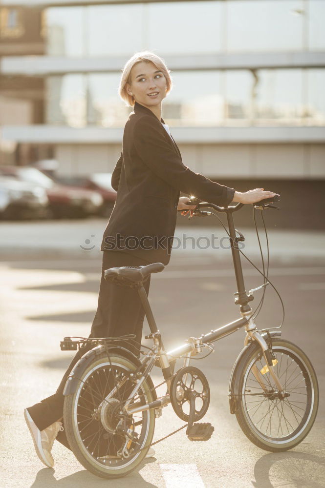 Young modern hipster riding bike trough urban city while sunset