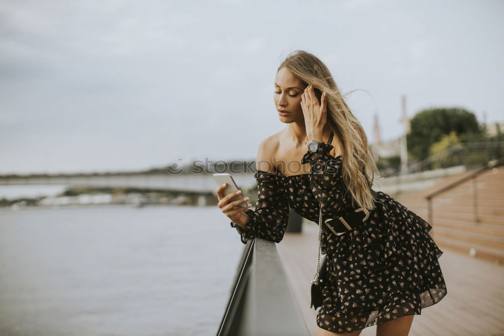 Similar – Brunette woman leaning on handrail at river