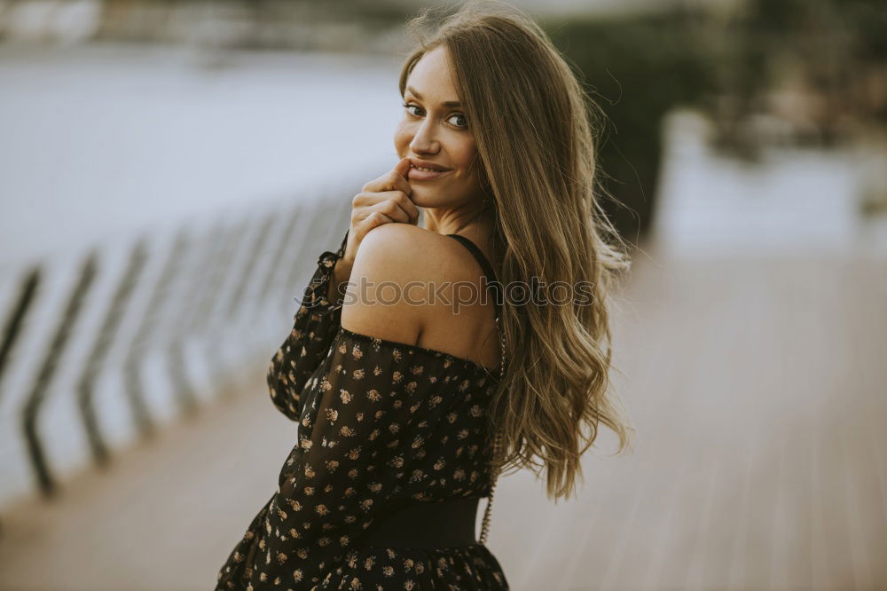 Similar – Brunette woman leaning on handrail at river