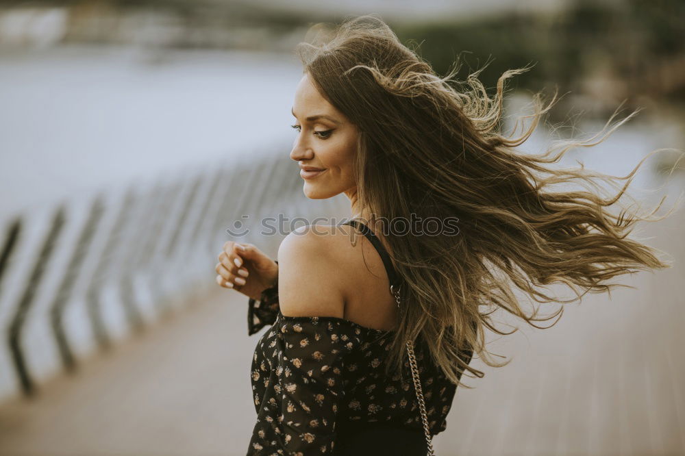 Similar – Brunette woman leaning on handrail at river