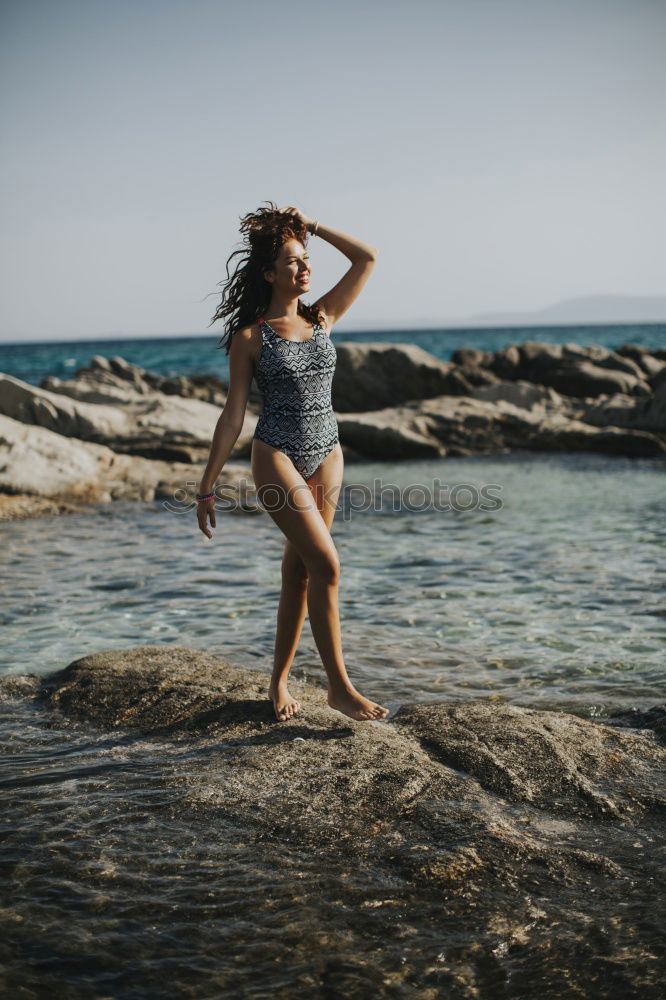 Similar – Image, Stock Photo Young girl standing on the rocks, watching sunset