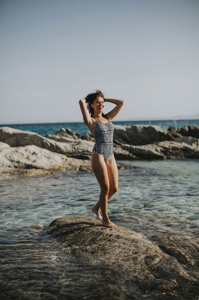 Image, Stock Photo Young girl standing on the rocks, watching sunset