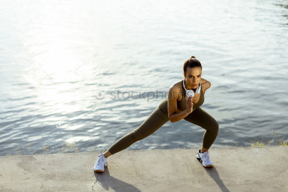 Young black woman doing stretching after running outdoors