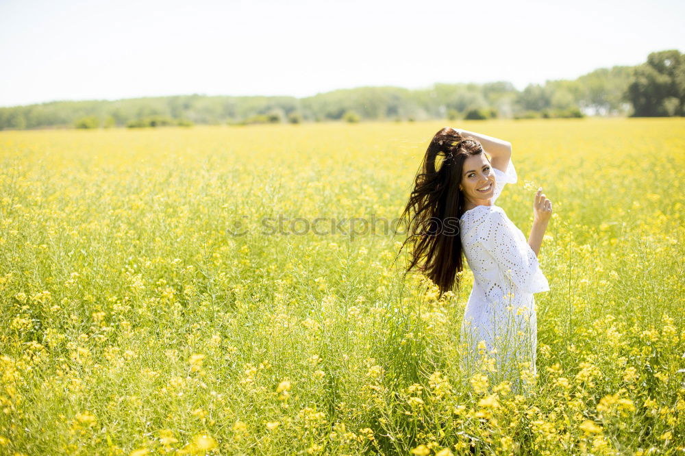 Similar – Image, Stock Photo Thoughtful young woman with bowed head on yellow meadow. Attractive girl with bowed head on a meadow of flowers in yellow to the horizon in the sunshine in spring or summer. Photo of a series.