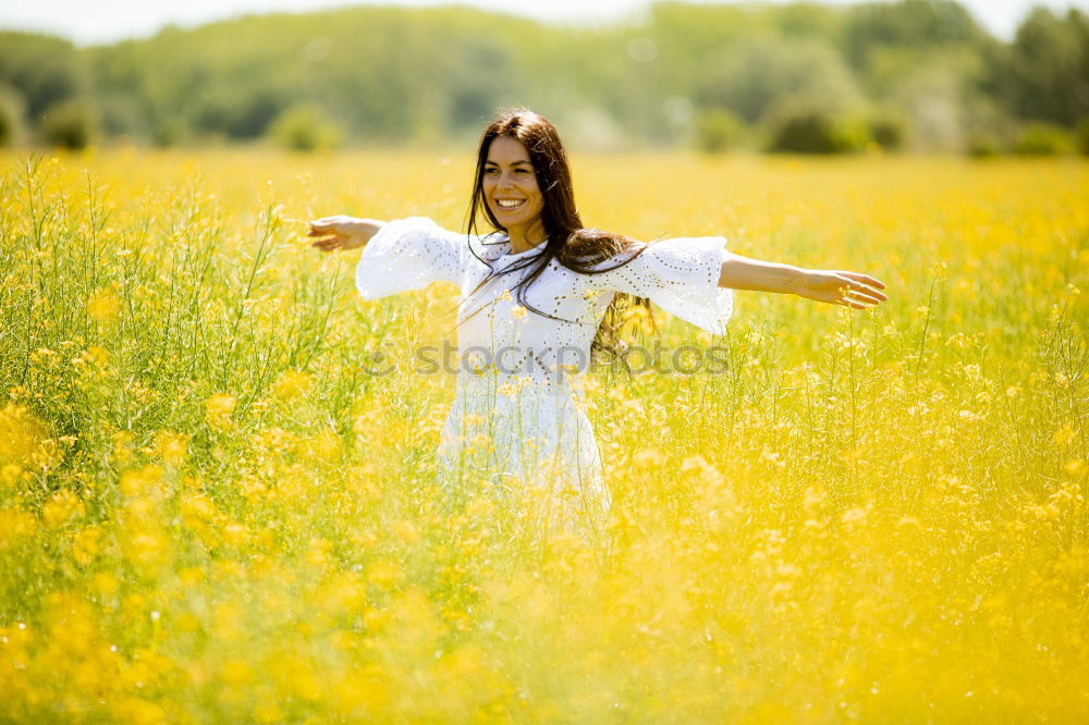 Similar – Image, Stock Photo Beautiful young woman enjoying the warm sun in the nature. Attractive girl is in yellow green meadow full of flowers. With head up and eyes closed she is happy about spring or summer.