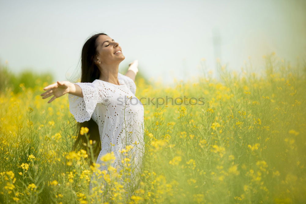 Similar – Image, Stock Photo Beautiful young woman enjoying the warm sun in the nature. Attractive girl is in yellow green meadow full of flowers. With head up and eyes closed she is happy about spring or summer.