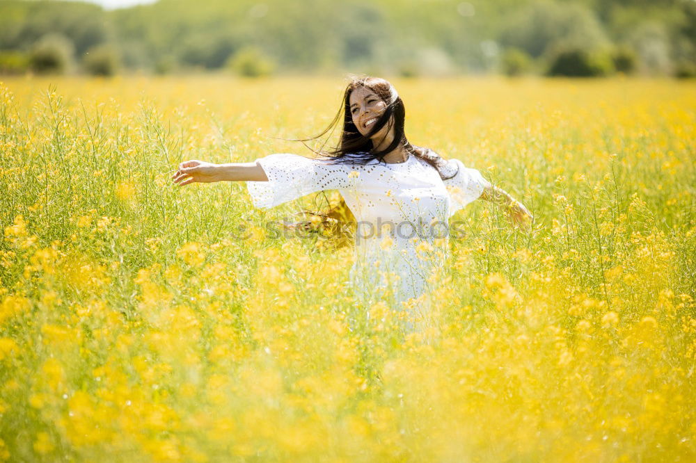 Similar – Image, Stock Photo Beautiful young woman enjoying the warm sun in the nature. Attractive girl is in yellow green meadow full of flowers. With head up and eyes closed she is happy about spring or summer.