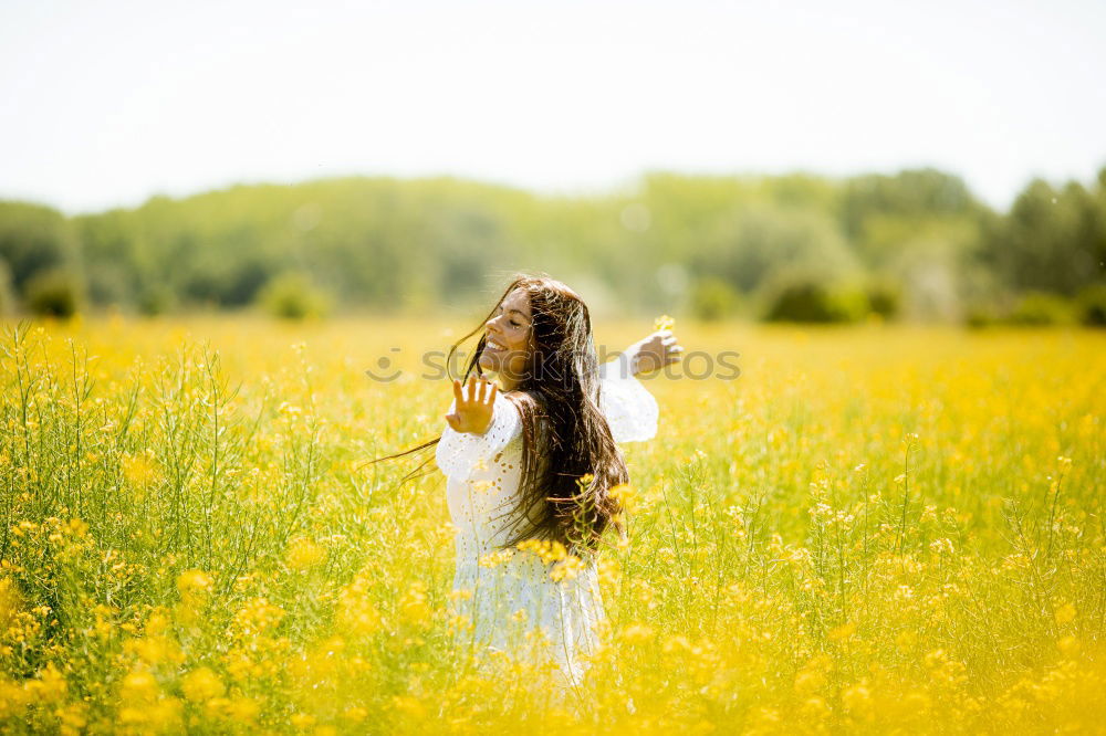 Similar – Image, Stock Photo Thoughtful young woman with bowed head on yellow meadow. Attractive girl with bowed head on a meadow of flowers in yellow to the horizon in the sunshine in spring or summer. Photo of a series.