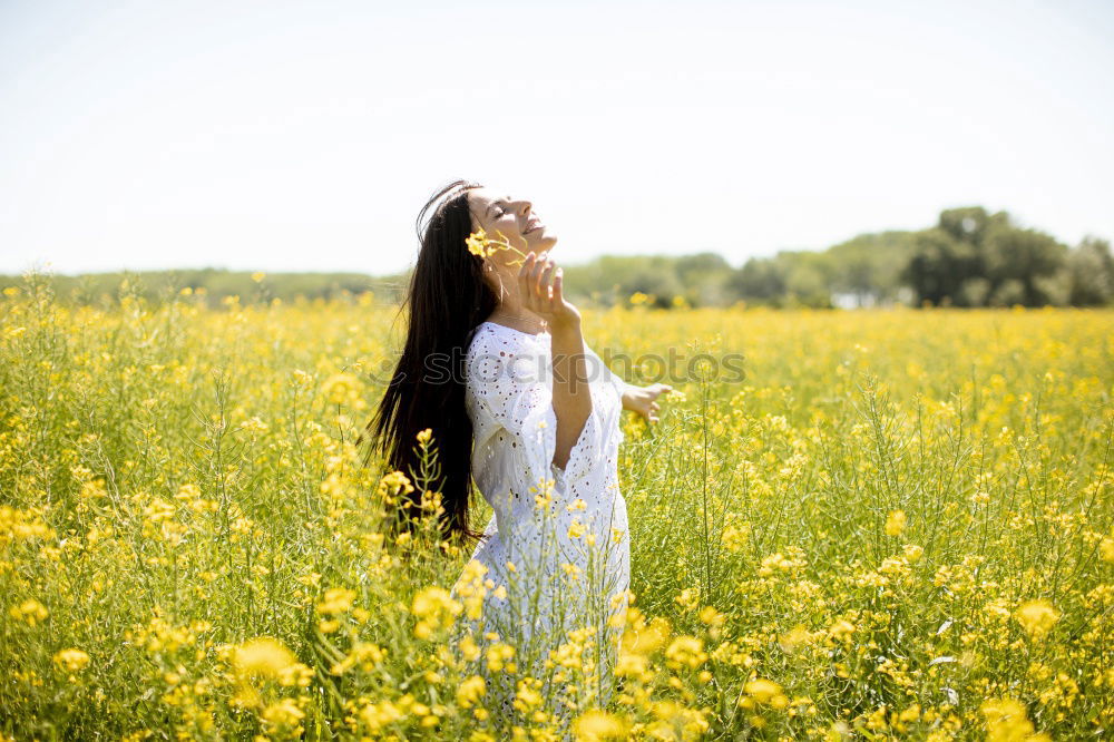 Similar – Image, Stock Photo Thoughtful young woman with bowed head on yellow meadow. Attractive girl with bowed head on a meadow of flowers in yellow to the horizon in the sunshine in spring or summer. Photo of a series.