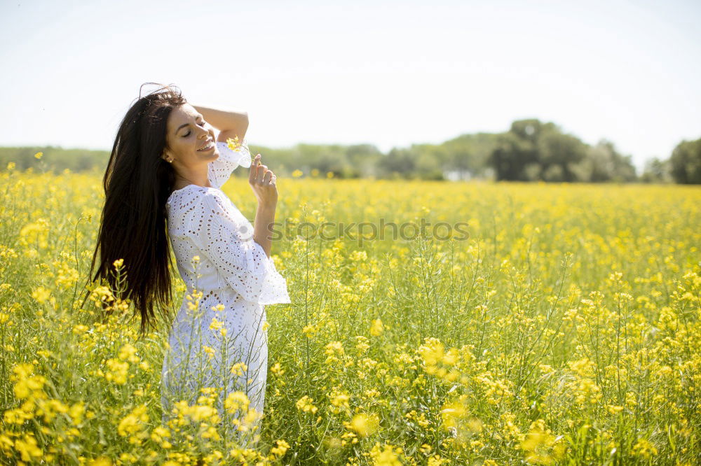 Similar – Image, Stock Photo Beautiful young woman enjoying the warm sun in the nature. Attractive girl is in yellow green meadow full of flowers. With head up and eyes closed she is happy about spring or summer.