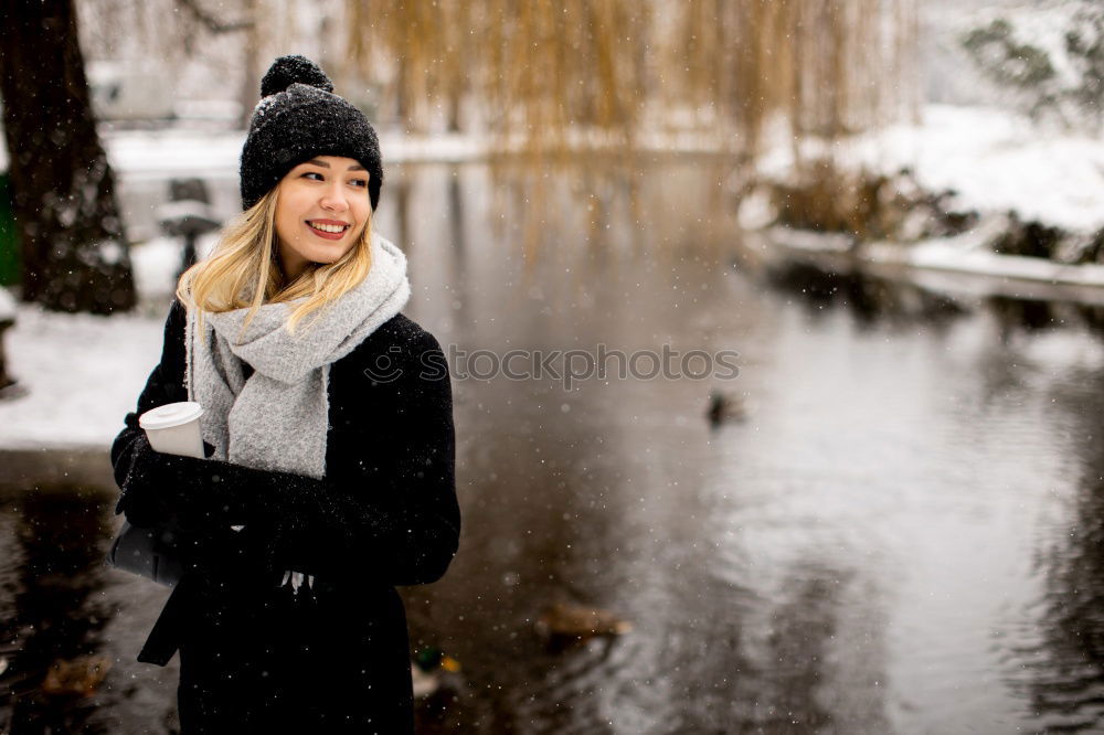 Similar – woman leaning against tree in winter landscape