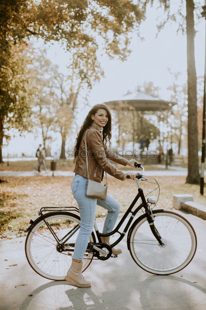 Similar – Young modern hipster riding bike trough urban city while sunset