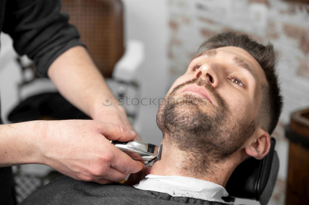 Similar – Foto Bild Detail der Hände eines Friseurs, der einem Kunden mit einem Rasiermesser die Haare schneidet