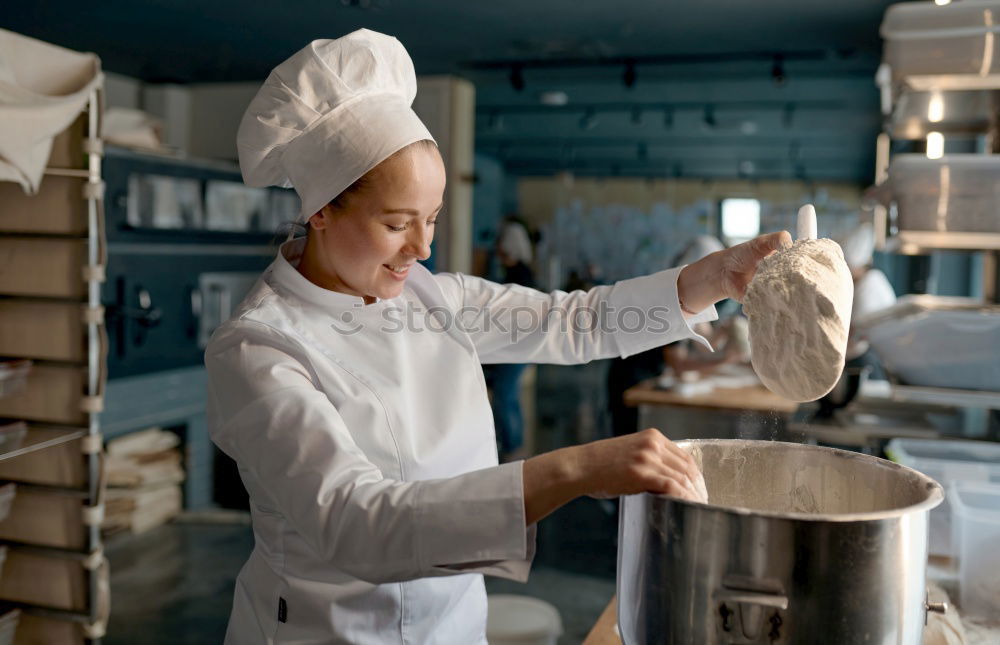 Similar – Image, Stock Photo A cook in a restaurant wearing a mask as a precaution against the coronavirus preparing the meal.