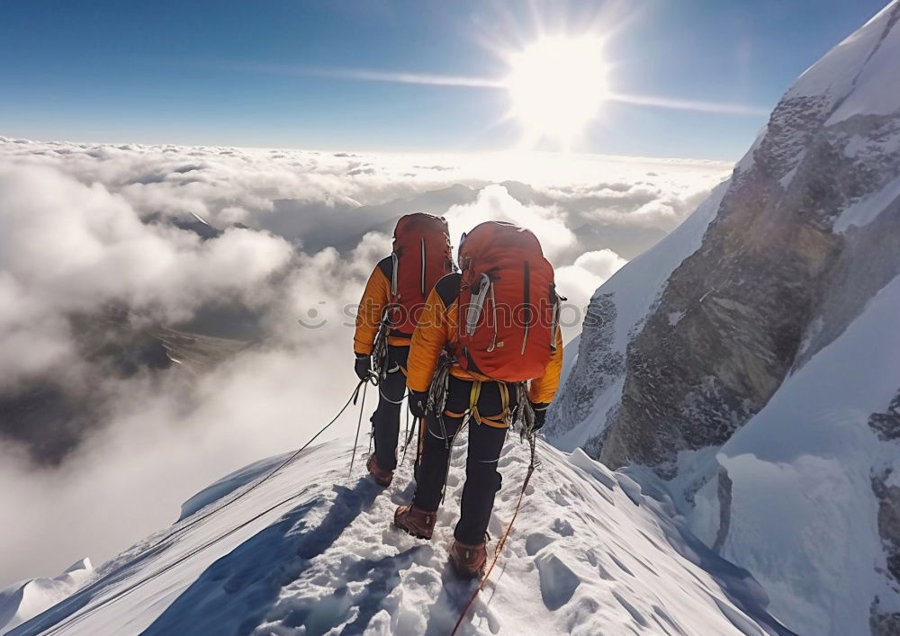 Similar – Climber helps another climber to reach the top of a mountain