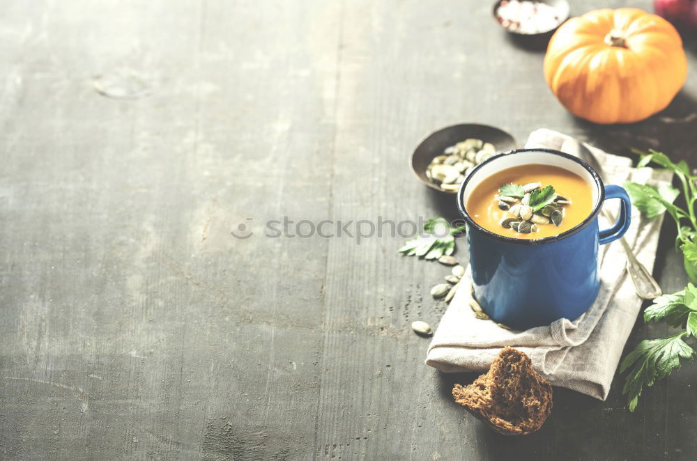 female hands holding an iron mug with carrot juice