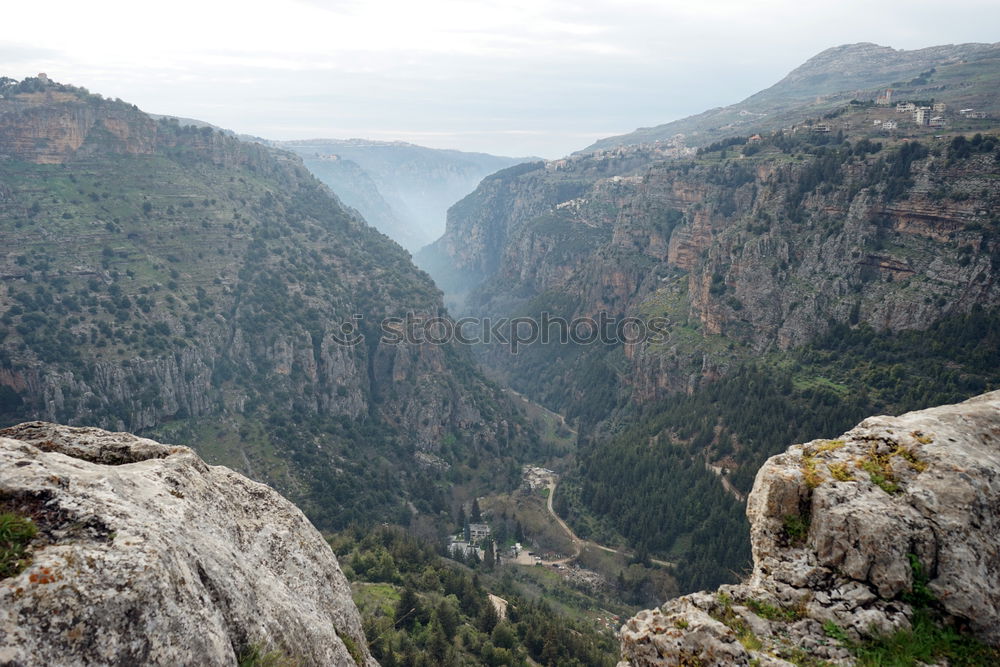 Similar – A steep cliff seen from above with a vast expanse of fields full of trees below