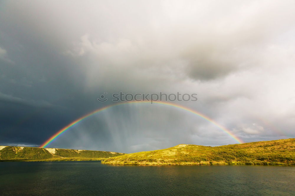 Similar – Image, Stock Photo A man stands at the beginning of a whole rainbow that spans a valley