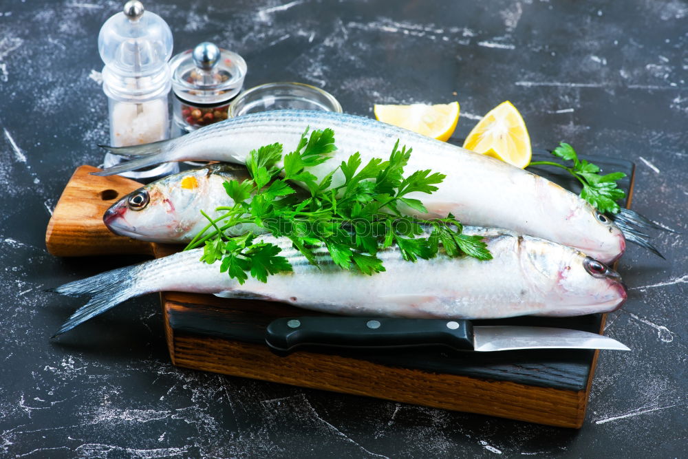 Similar – Raw fish on white paper with ingredients for cooking