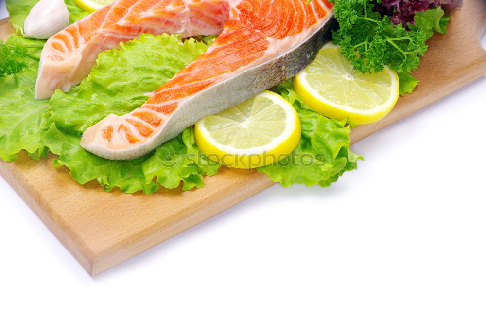 Raw salmon fillet with green herbs and lemon