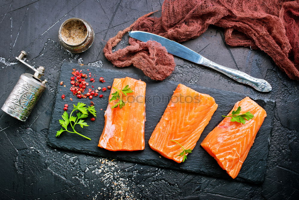 Similar – Salmon fish fillets on chopping board with fresh vegetables