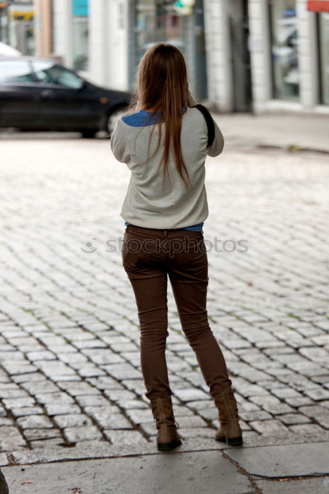 Similar – thoughtful woman with dreadlocks, in jeans and brown leather jacket is standing at an old dilapidated house wall