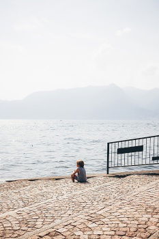 Similar – Rear view of a woman sitting on a wooden bench and looking at a lake