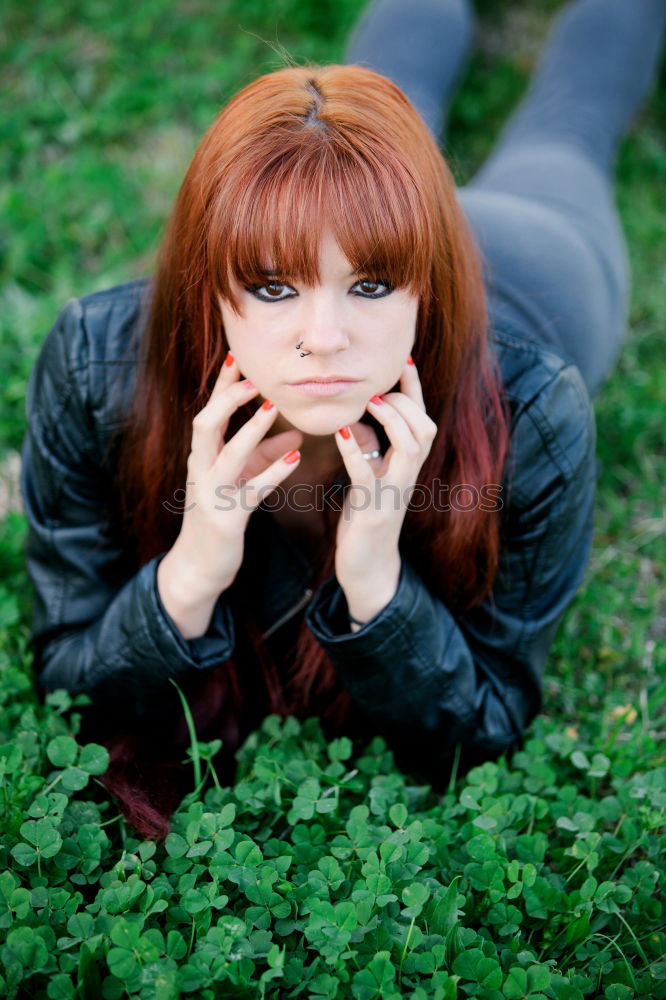 Similar – Redhead woman smelling a flower in a park