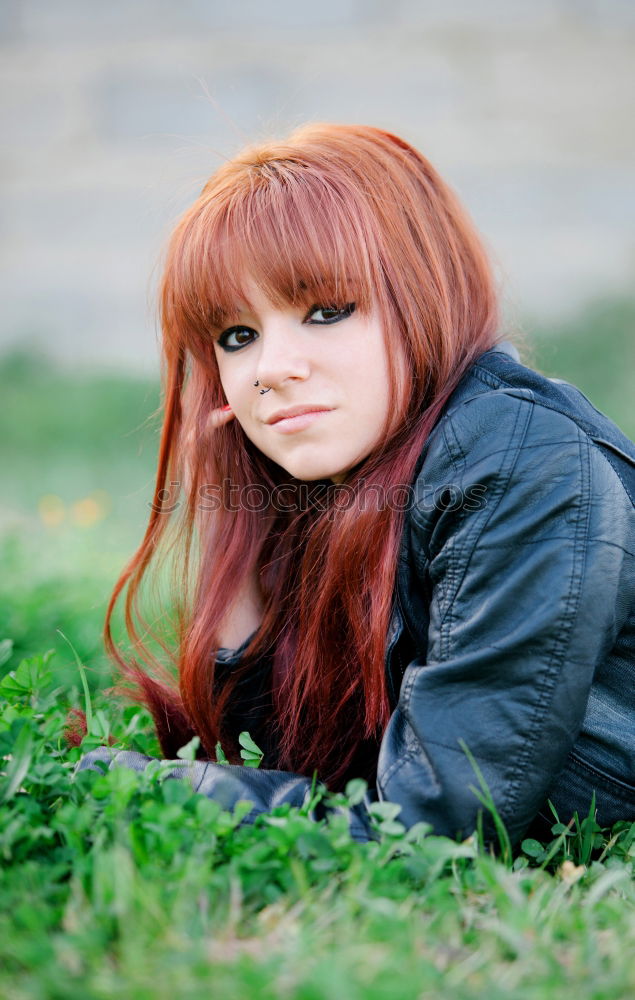 Similar – Redhead woman smelling a flower in a park