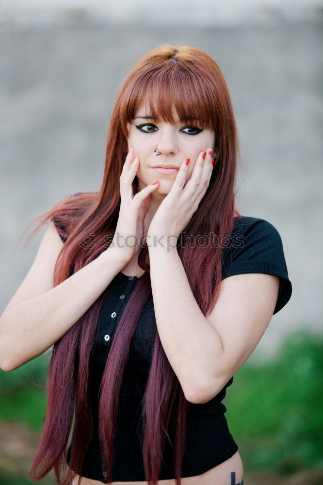 Similar – Redhead woman smelling a flower in a park