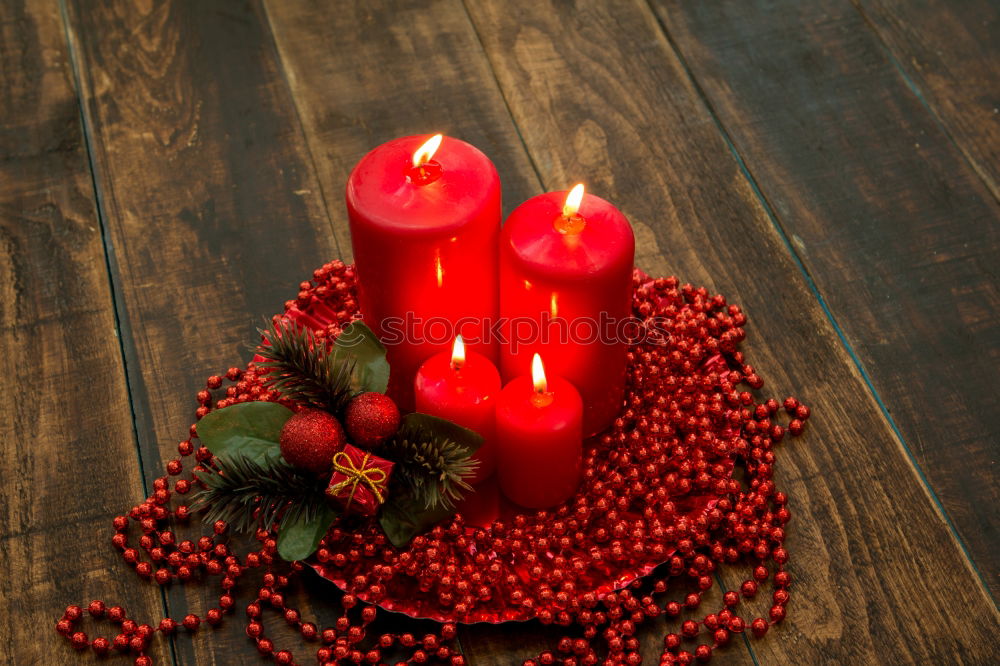 Similar – Lighted candles with red colored pearls around