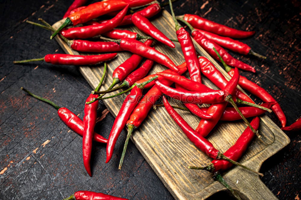 Similar – Image, Stock Photo Red hot chili peppers on a wooden background