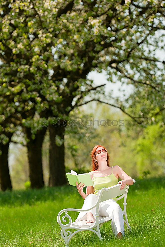 Similar – Jule Young woman with dreads is sitting on a bench in the green.