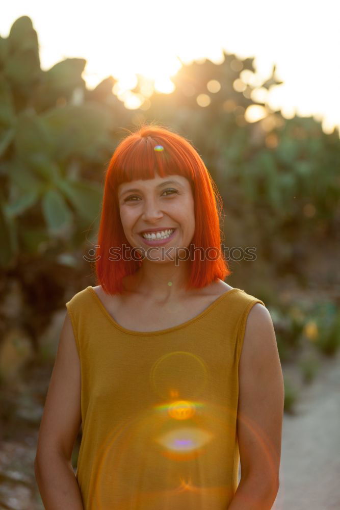 Similar – Redhead woman smelling a flower in a park