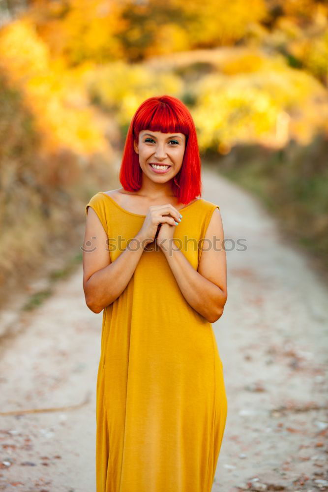 Similar – Redhead woman smelling a flower in a park