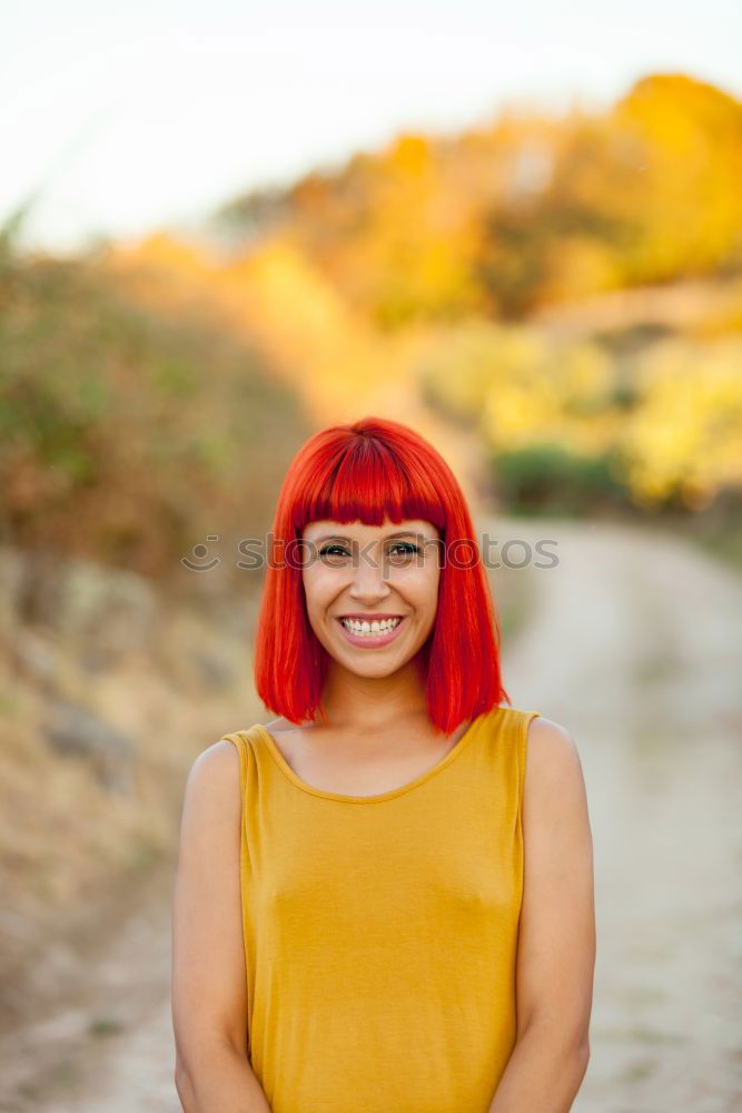 Similar – Redhead woman smelling a flower in a park