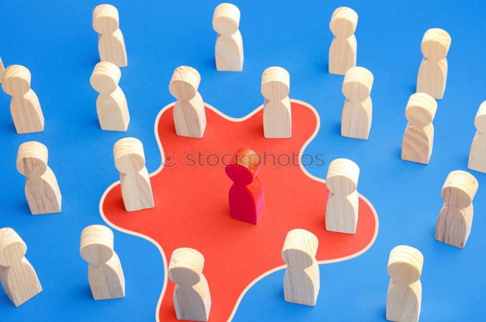 Similar – A red playing figure stands together with white playing figures in a circle on a blue background