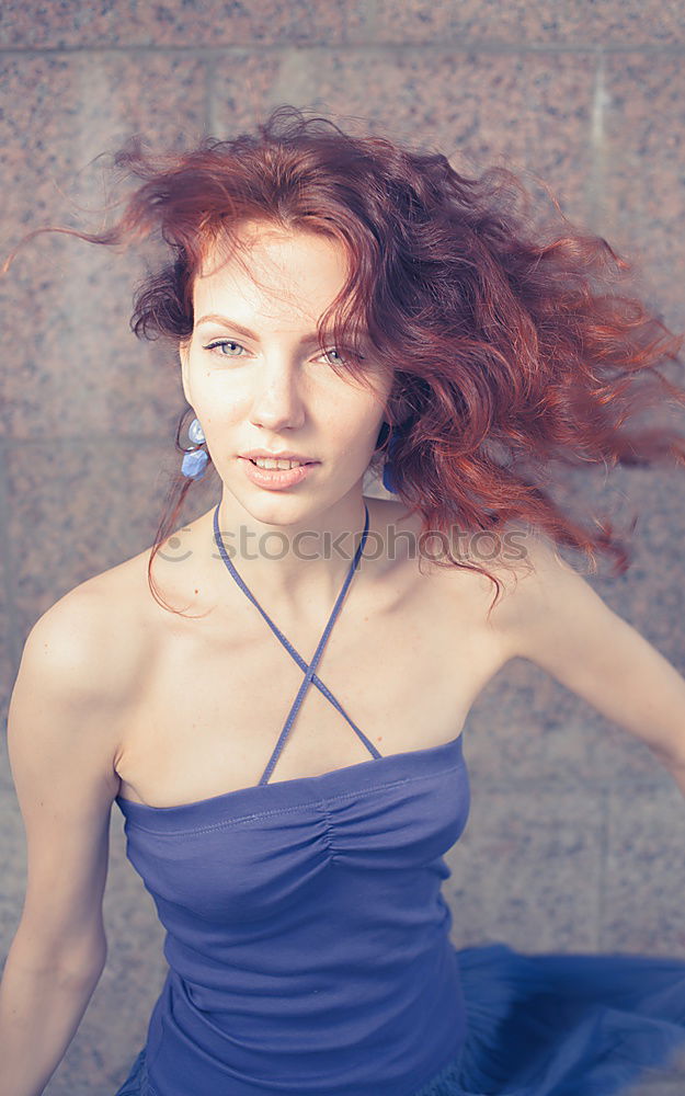 Similar – young redhead woman agains blue wall is sending a kiss